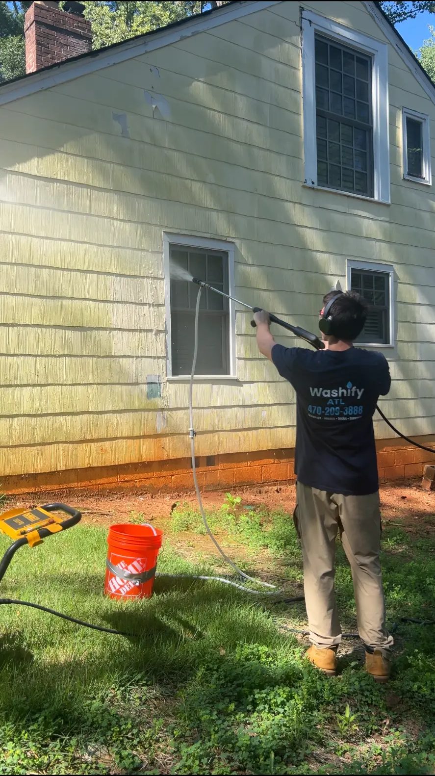 Matteo washing the siding of a local home