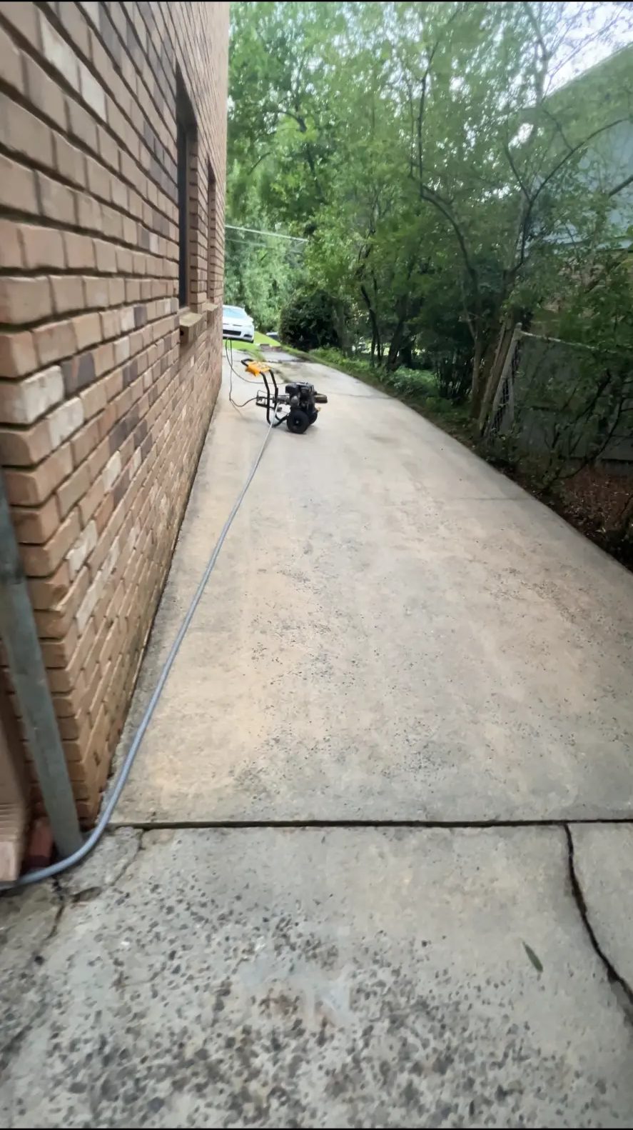 Freshly cleaned side driveway beside a brick home